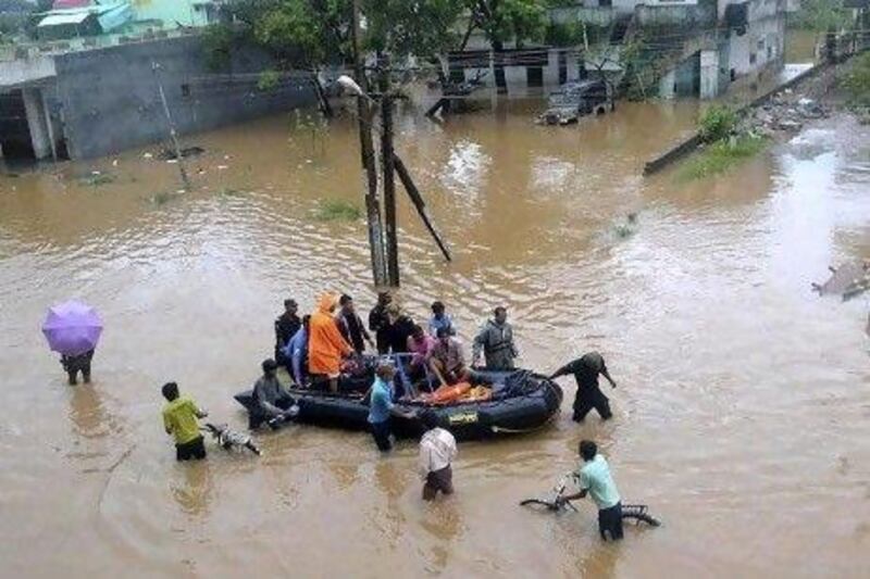Indians wade through flood waters after heavy rainfall as they move to higher ground in Vishakapatnam.