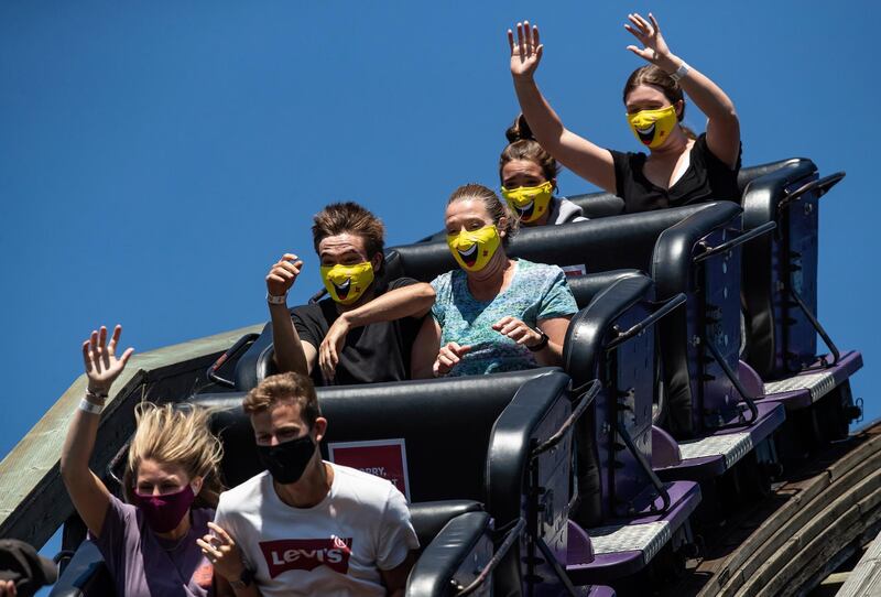 People ride the wooden roller coaster at Playland amusement park at the Pacific National Exhibition, in Vancouver, Canada. The Canadian Press via AP