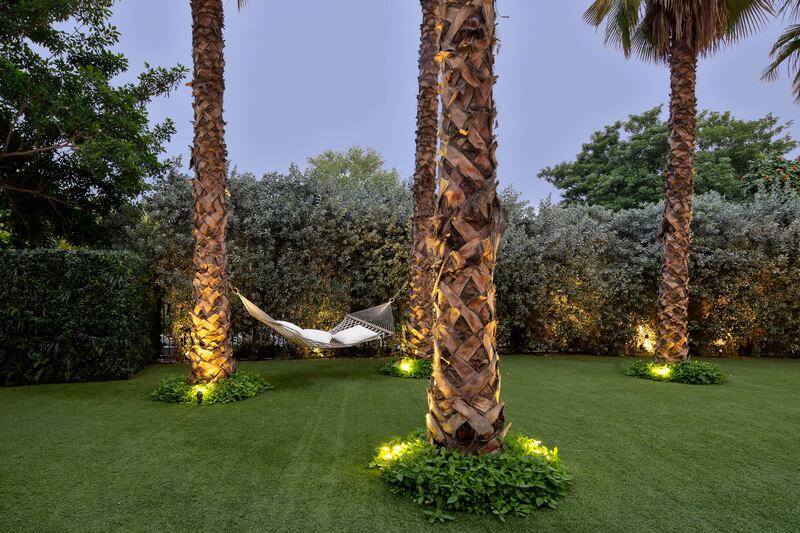 Palm trees and a hammock add a tropical flavour to the garden.