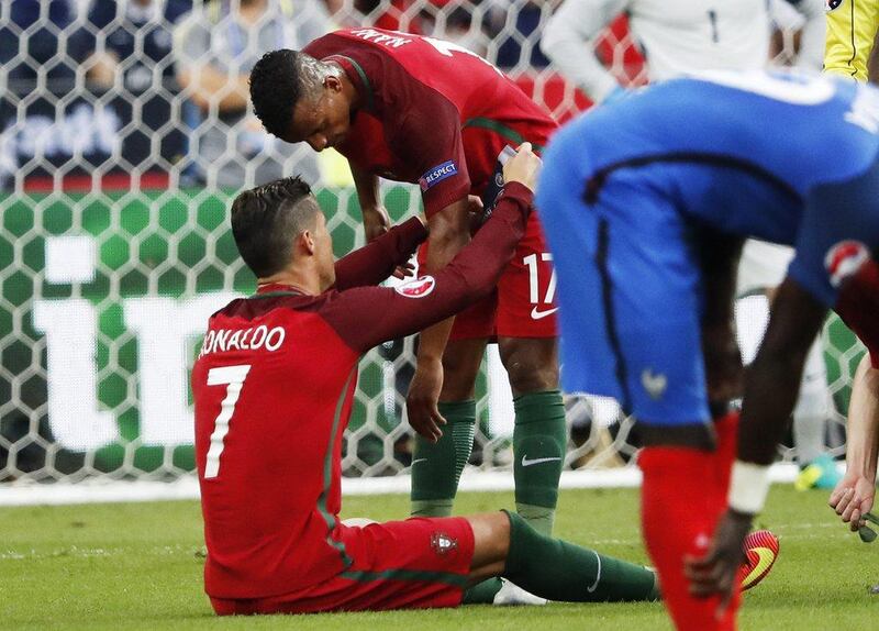 Cristiano Ronaldo of Portugal gives the captain’s armband to teammate Nani as he is forced to pull out of the game due to injury during the Uefa Euro 2016 Final match between Portugal and France at Stade de France in Saint-Denis, France, 10 July 2016. Abedin Taherkenareh / EPA