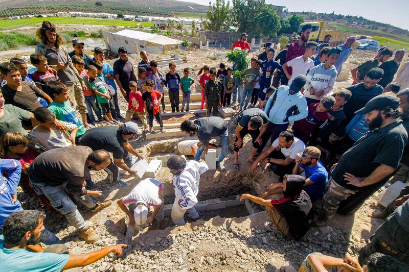 Mourners prepare a grave for a  Syrian rebel killed by a Russian raid in the countryside of Aleppo, on September 26, 2021.  AFP