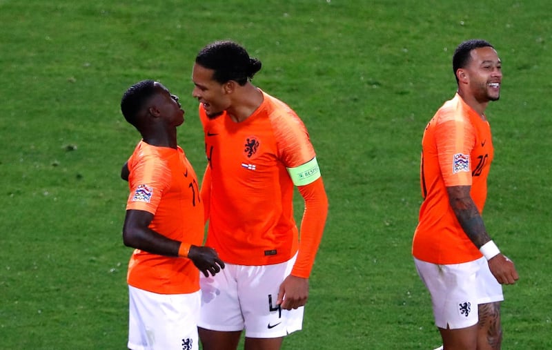 Netherlands' Quincy Promes, left, celebrates with Van Dijk and Memphis Depay, right, after scoring his side's third goal. AP Photo
