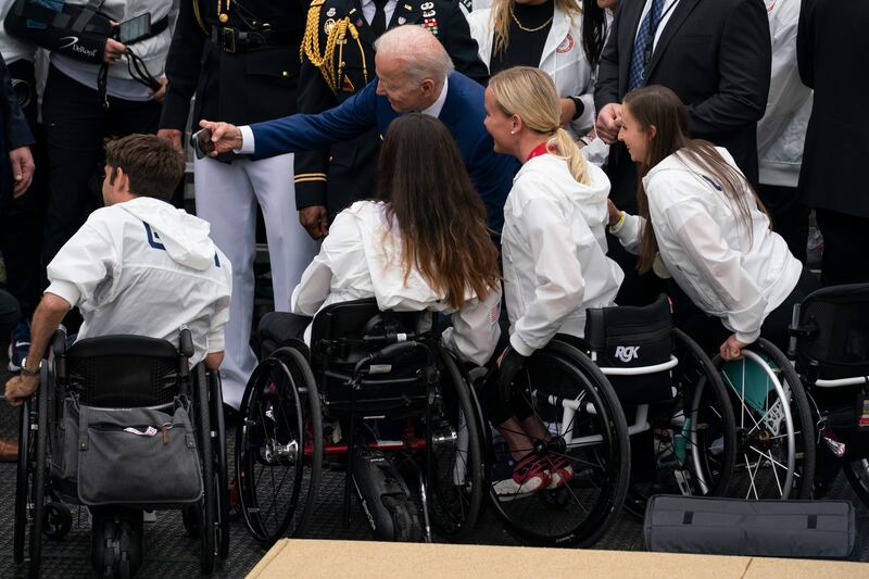 President Joe Biden poses for photographs with members of Team USA. AP