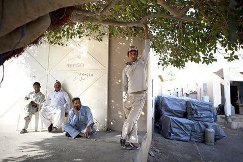 Men take a break from work near a warehouse in the Iranian Souk in Khasab, a small port town in Musandam, Oman. Silvia Razgova / The National