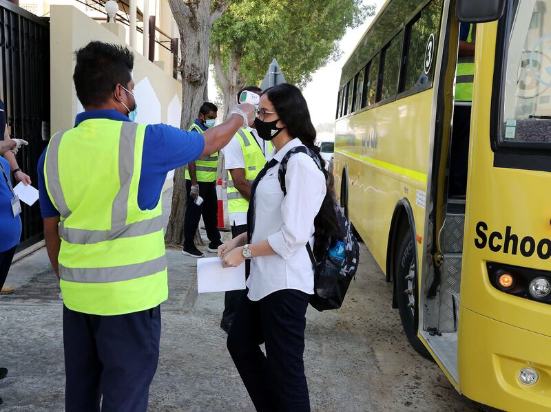 SHARJAH, UNITED ARAB EMIRATES , September 28 – 2020 :- Staff member checking the temperature of the student at the entrance gate on the first day of the school after reopening at the Victoria English School in Sharjah. New Covid safety setup placed in different areas of the school such as hand sanitizer, safety message, social distancing stickers pasted on the floor, disinfection tunnels installed at all the gates of the school. (Pawan Singh / The National) For News. Story by Salam