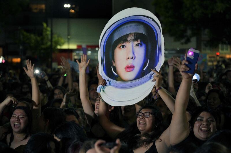 Fans of BTS unable to attend the concert gather outside the Monumental Stadium, Buenos Aires, to listen to Jin perform his single 'The Astronaut' with Coldplay. All photos: AFP