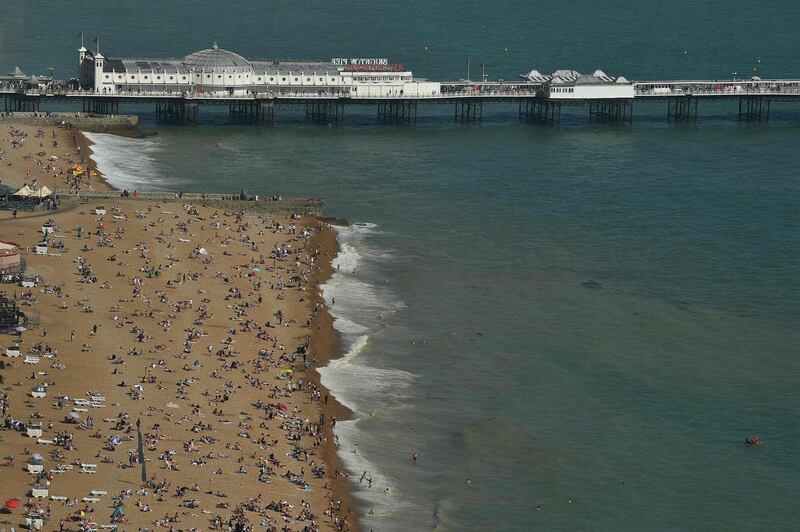 Beachgoers relax by the sea in Brighton, southern England. AFP