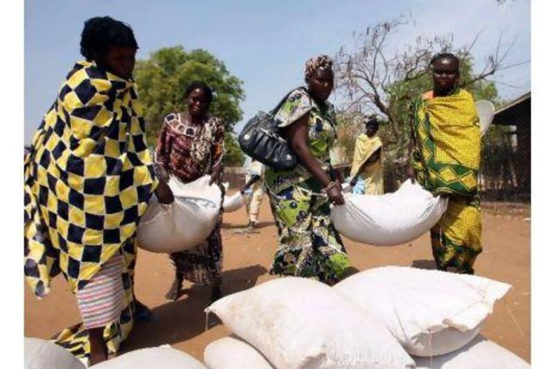 Southern Sudanese women carry sacks of food distributions by the World Food Programme in Juba, southern Sudan, yesterday.