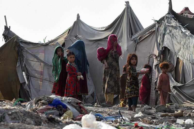 Afghan children gather outside tents in the Afghan Basti area outside Lahore, Pakistan. AFP