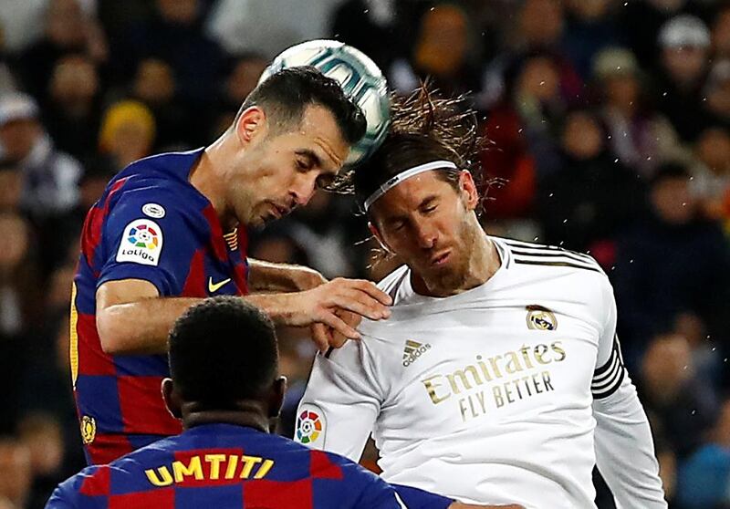 Real Madrid's Sergio Ramos, right, and Sergio Busquets of Barcelona challenge for a header during the clasico on February 3, 2020. Real won the match 2-0 at the Bernabeu. Reuters
