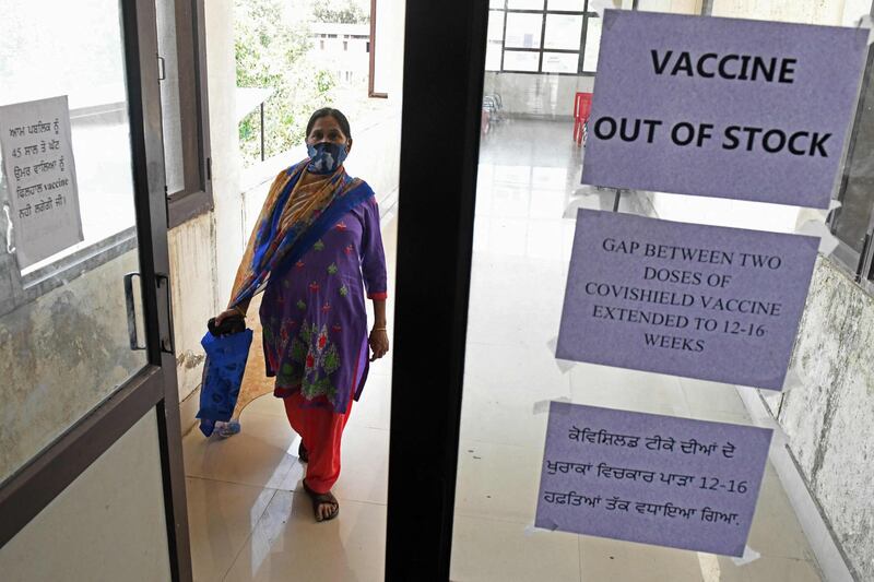 A woman walks past notices displayed in a civil hospital indicating the Covid-19 vaccine is out of stock, in Amritsar, India. AFP