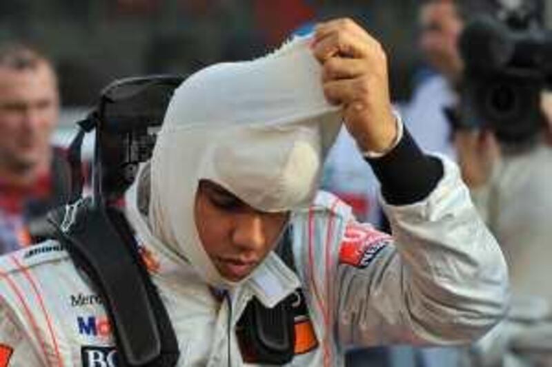 McLaren Mercedes driver Lewis Hamilton of Britain prepares his mask prior to the start of the Abu Dhabi Formula One Grand Prix at the Yas Marina racetrack in Abu Dhabi, United Arab Emirates, Sunday, Nov. 1, 2009. Hamilton later retired from the race.  (AP Photo/Gero Breloer) *** Local Caption ***  BRO118_EMIRATES_ABU_DHABI_F1_GP_AUTO_RACING.jpg