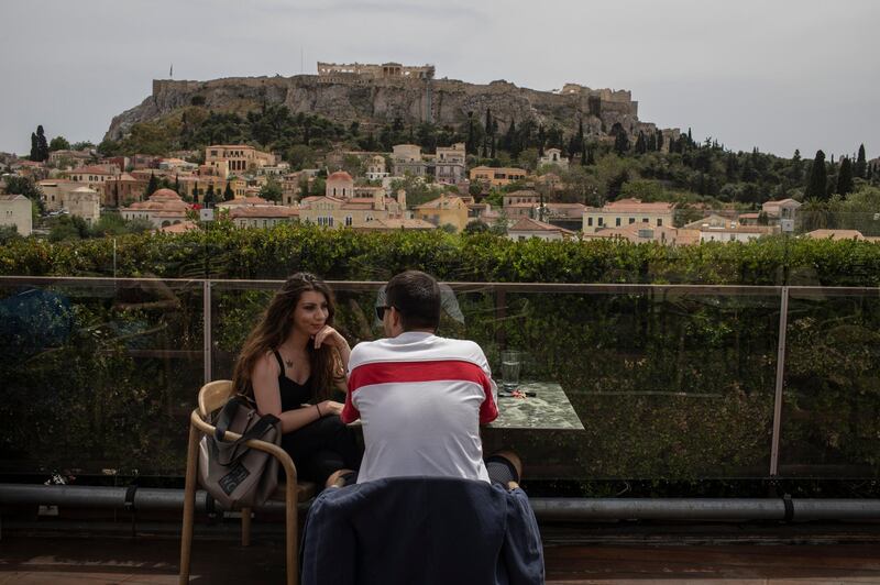 A man and a woman drink coffee in the Monastiraki district of Athens. AP Photo