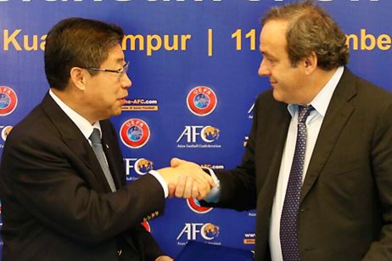 Acting AFC president Zhang Jilong and Uefa president Michel Platini.