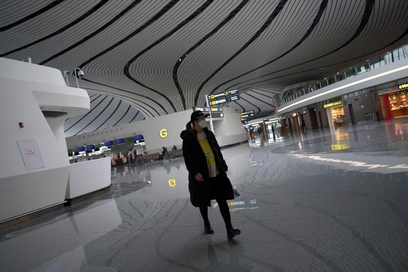 A woman wearing a face mask walks at the Beijing Daxing International Airport, as the country is hit by an outbreak of the novel coronavirus, in Beijing, China February 20, 2020. REUTERS/Tingshu Wang