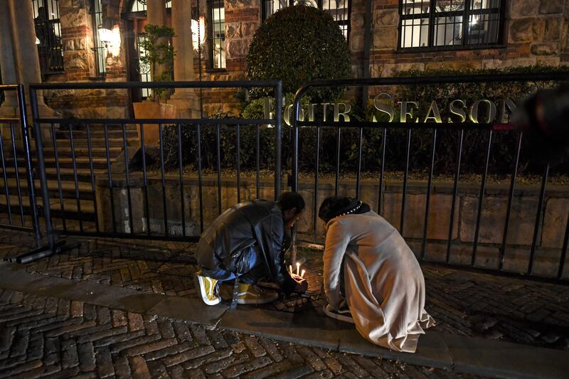 People light candles in front the hotel where Hawkins died. AFP