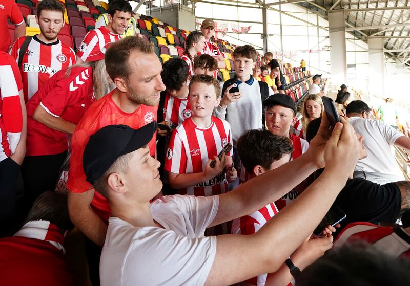 Brentford's Christian Eriksen poses with fans in the stands. PA
