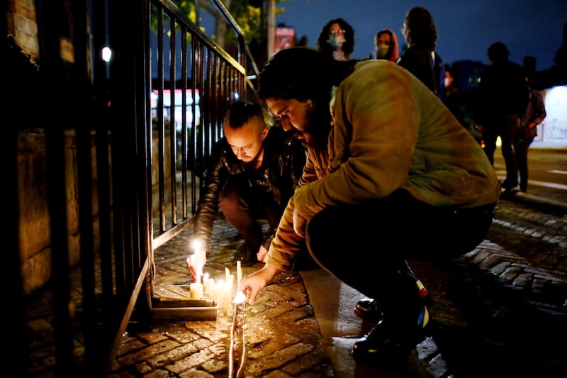 Fans place lights in front of the hotel where Hawkins died. AP