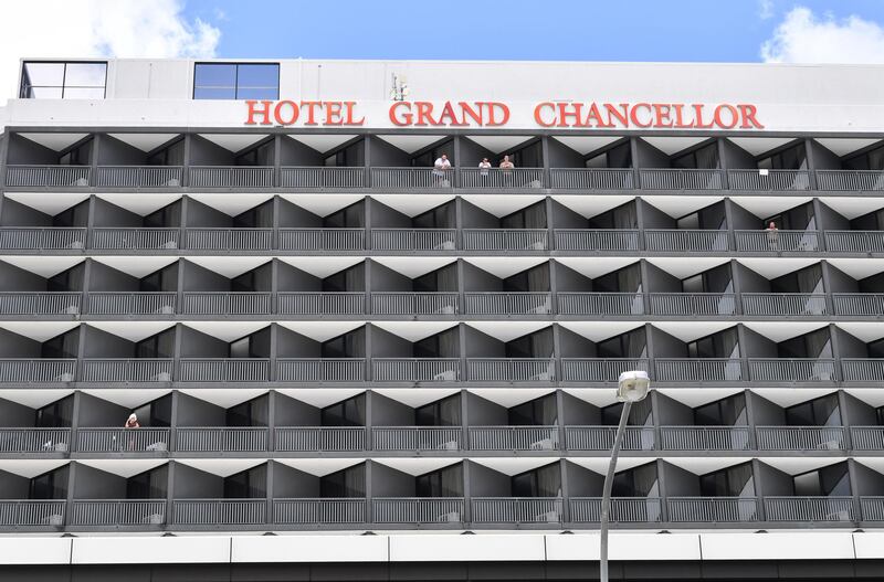 Hotel guests are seen on a balcony at the Hotel Grand Chancellor in Brisbane, Australia, as the Queensland government is shutting it down after six people staying there contracted the UK strain of coronavirus. EPA
