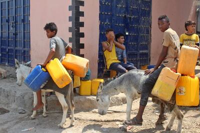 Yemeni youths commute on donkeys carrying plastic jerrycans in the southern city of Aden, on September 16, 2020. Yemenis are resorting to using donkeys to transport water and haul goods, as the long years of conflict that have ravaged the economy make gas-guzzling vehicles unaffordable for many. / AFP / Saleh Al-OBEIDI
