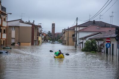 A local travels by an inflatable kayak in Cesena, Italy. EPA