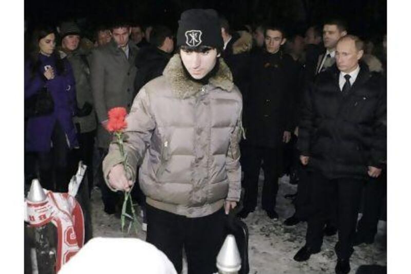 The Russian prime minister, Vladimir Putin, watches a man lay flowers at the grave of a Slavic fan killed this month during a clash with supporters from the Caucasus region.
Alexei Nikolsky / AP