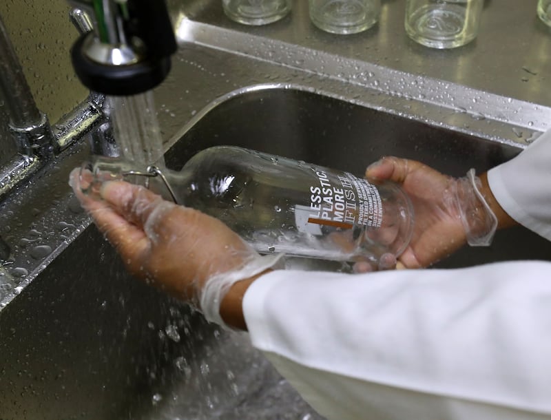 Milan washes used bottles by hand before putting them into the system