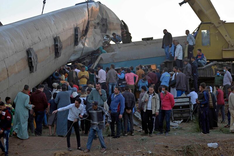People gather around the wreckage of two trains that collided in the Tahta district of Sohag province, some 460 kilometres (285 miles) south of the Egyptian capital Cairo, reportedly killing at least 32 people and injuring scores of others. AFP