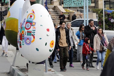 Iranians walk next to a colorful decoration in the shape of an egg, a symbol of 'Nowruz', the Persian New Year, on display in a street ahead of Nowruz celebrations in Tehran, Iran, 18 March 2024.  Nowruz, which this year falls on 20 March and has been celebrated for at least three thousand years, is the most revered celebration in the greater Persian world, which includes the countries of Iran, Afghanistan, Azerbaijan, Turkey, and portions of western China and northern Iraq.   EPA / ABEDIN TAHERKENAREH