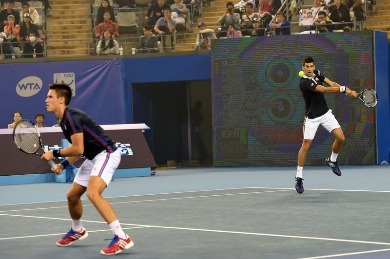 Novak Djokovic hits a return while playing a doubles match on Tuesday with brother Djordje at the ATP Beijing tournament. Goh Chai Hin / AFP