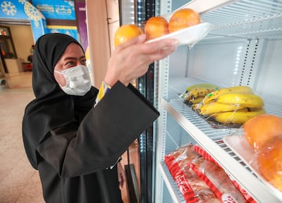 Fresh fruit, bread, water, yoghurt and juice is added daily to a fridge set up by the UAE Food Bank at the Lulu Village, in Muhaisnah in Dubai. Victor Besa / The National