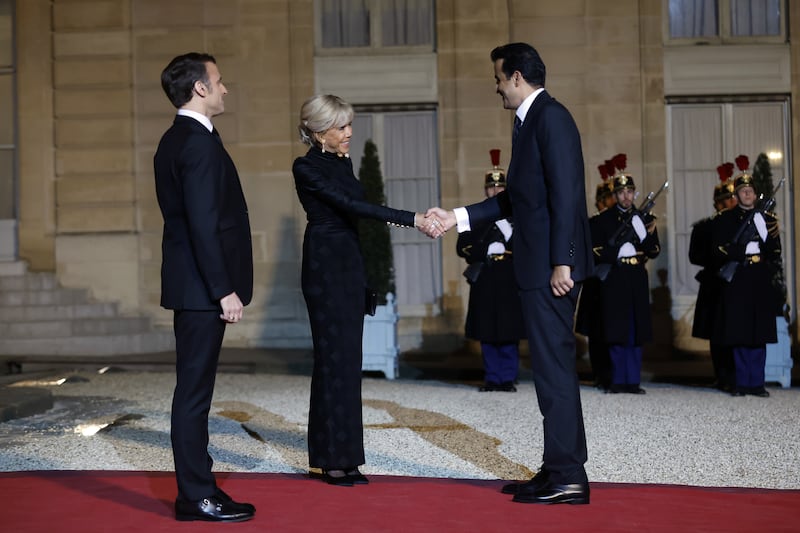 Ms Macron greets Sheikh Tamim as her husband watches on. EPA