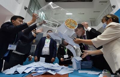 Members of a local electoral commission empty a ballot box at a polling station after Kazakhstan's presidential elections in Astana on Sunday. AFP