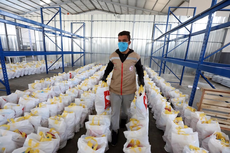 A Tunisian Red Crescent member prepares food packages to be delivered to the elderly and needy families during the ongoing emergency measures over the ongoing pandemic of the coronavirus, in Ben Arous, Tunisia.  EPA