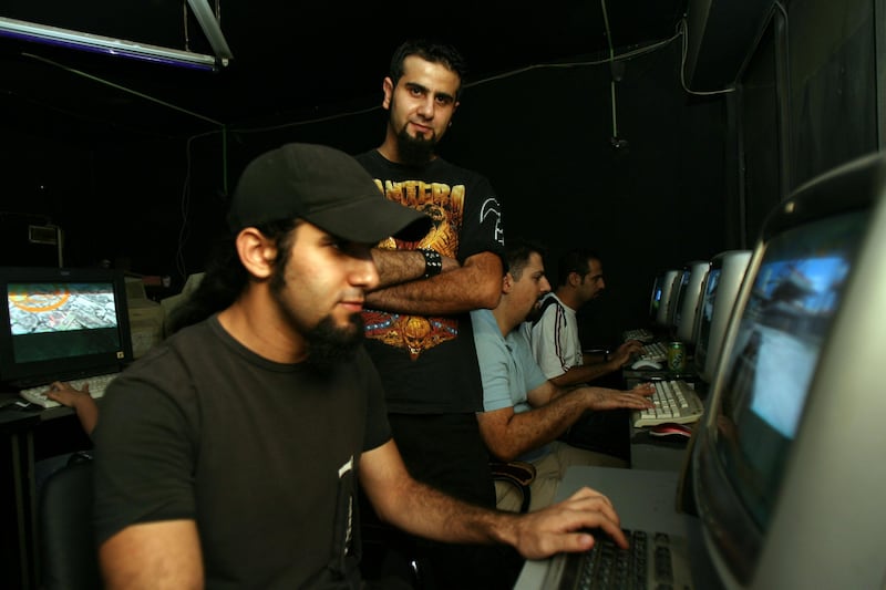  Morad (L) plays a game in the internet cafe as his brother Hosam (2nd from L) watches, in Amman September 25, 2008. (Salah Malkawi/ The National)