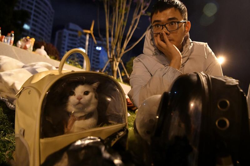 A resident spends the night outdoors with his cat in the city of Dali, following an earthquake in nearby Yangbi county. At least three people were killed in the earthquake, with 27 injured. Reuters