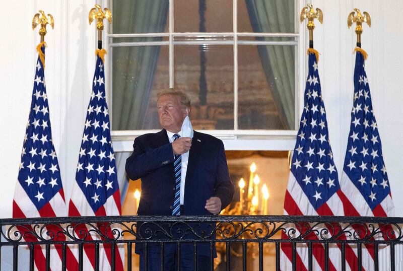 TOPSHOT - WASHINGTON, DC - OCTOBER 05: U.S. President Donald Trump removes his mask upon return to the White House from Walter Reed National Military Medical Center on October 05, 2020 in Washington, DC. Trump spent three days hospitalized for coronavirus.   Win McNamee/Getty Images/AFP / AFP / GETTY IMAGES NORTH AMERICA / WIN MCNAMEE
