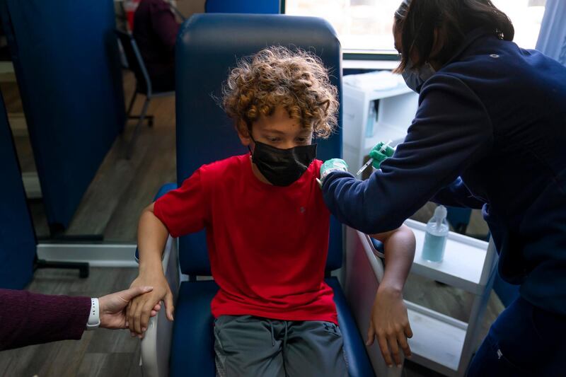 Max Cuevas, 12, holds his mother's hand as he receives the Pfizer COVID-19 vaccineÂ from nurse practitioner Nicole Noche at Families Together of Orange County in Tustin, Calif., Thursday, May 13, 2021. The state began vaccinating children ages 12 to 15 Thursday. (AP Photo/Jae C. Hong)
