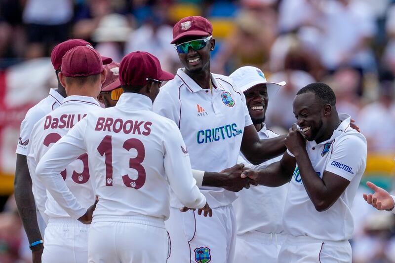 West Indies bowler Kemar Roach, right, celebrates after claiming the wicket of Joe Root. AP