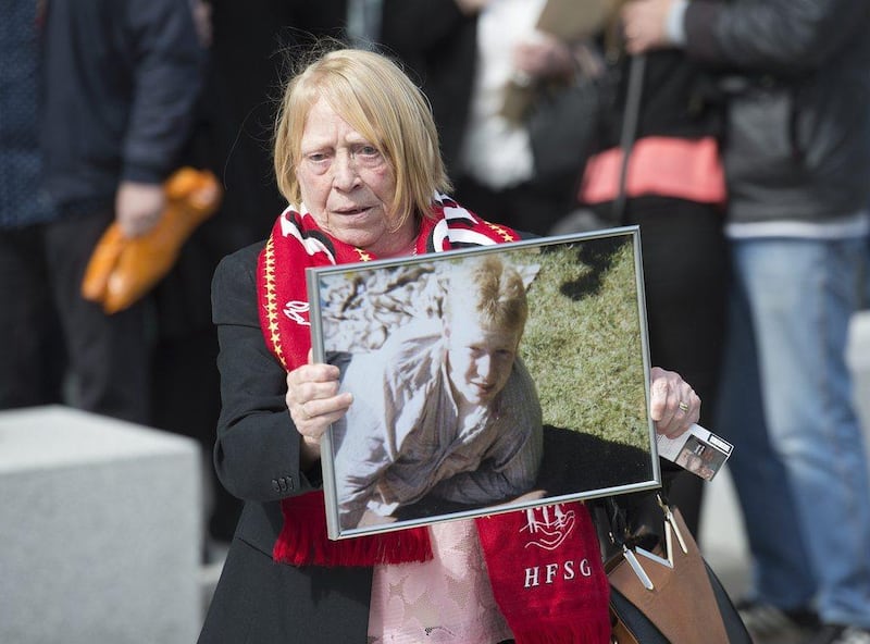 Familiy members of victims show a photograph of their loved one, as they emerge from court after hearing the unlawful killing verdict at the Hillsborough inquest at the Coroners Court in Warrington. Peter Powell / EPA