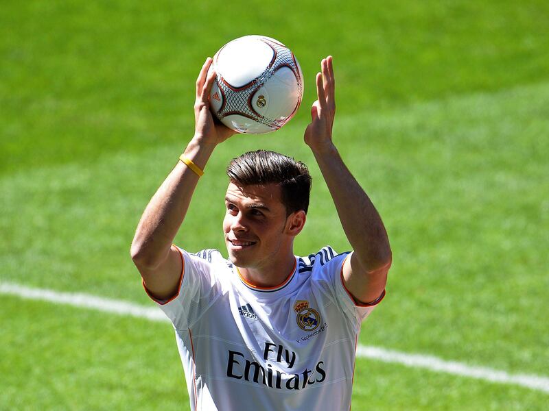 New Welsh striker of Real Madrid Gareth Bale gestures on the pitch during his presentation at the Santiago Bernabeu stadium in Madrid on September 2, 2013. Bale was unveiled as a Real Madrid player today after his prolonged transfer from Tottenham Hotspur was finally completed for an unconfirmed world record fee late September 1. The Welshman has agreed a six-year deal believed to be worth 10 million euros net a year and will be presented to the media and the club's fans after undergoing a medical in the Spanish capital.   AFP PHOTO/ GERARD JULIEN
 *** Local Caption ***  854902-01-08.jpg