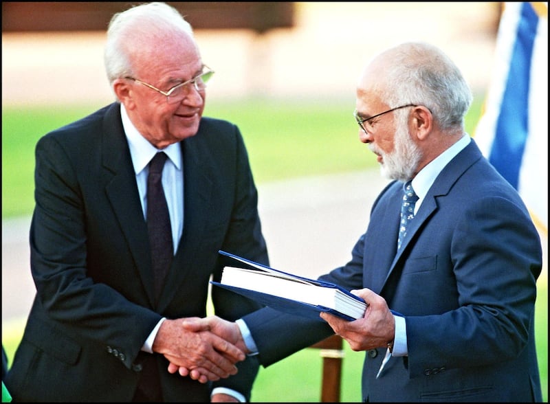 (FILES) Hussein Ibn Talal, King of Jordan (r) and Israeli Premier Yitzhak Rabin (l) shake hands after they exchanged the documents of the Peace Treaty at Beit Gabriel conference center 10 November 1994 on the southern shore of the Sea of Galilee. (Photo by SVEN NACKSTRAND / AFP FILES / AFP)