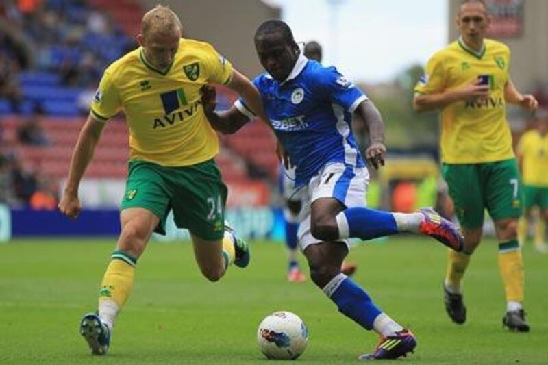 Wigan Athletic‘s Victor Moses, centre, challenges Norwich’s Ritchie De Laet in Saturday’s opening game of the season.