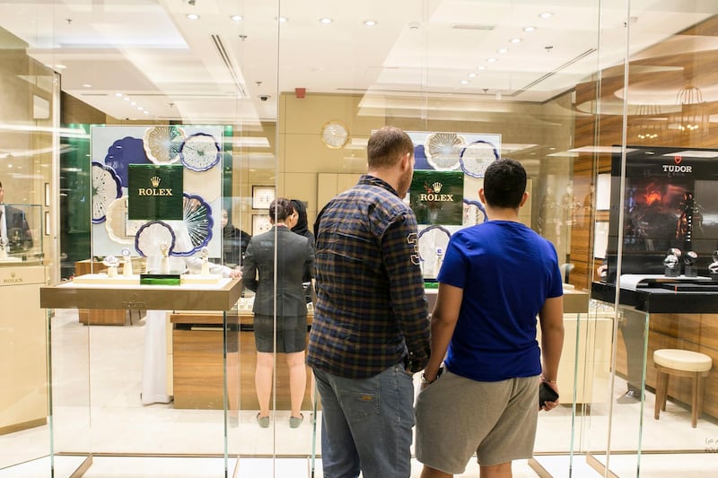 DUBAI, UNITED ARAB EMIRATES, JULY 1, 2015. A man and a boy look into Rolex's store at Mall of the Emirates. Photographer: Reem Mohammed / The National  (Hold for Business) *** Local Caption ***  RM_20150701_MALL_012.JPG