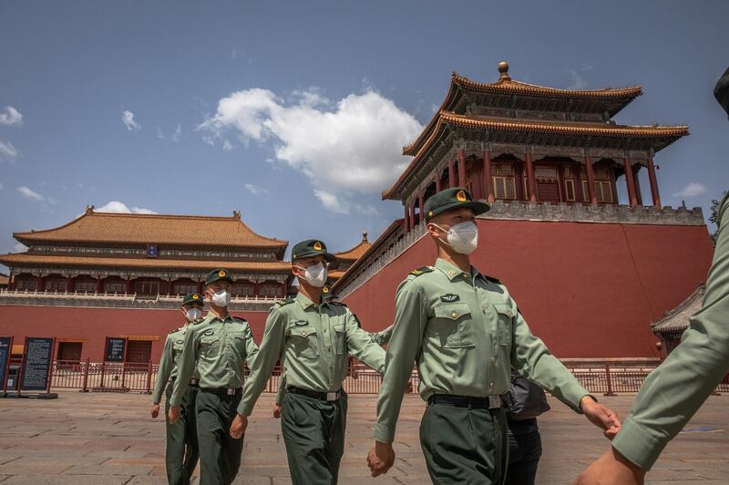 epa08428963 Chinese People's Liberation Army (PLA) soldiers wearing protective face masks march past the entrance to the Forbidden City, in Beijing, China, 18 May 2020. China will hold the Chinese People's Political Consultative Conference (CPPCC) on 21 May and the National People's Congress (NPC) on 22 May after the two major political meetings initially planned to be held in March 2020 were postponed amid the coronavirus outbreak.  EPA/ROMAN PILIPEY