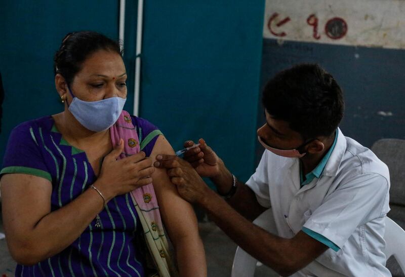 A health worker administers a dose of Covishield, Serum Institute of India's version of the AstraZeneca vaccine, to a woman in Ahmedabad, India. AP Photo