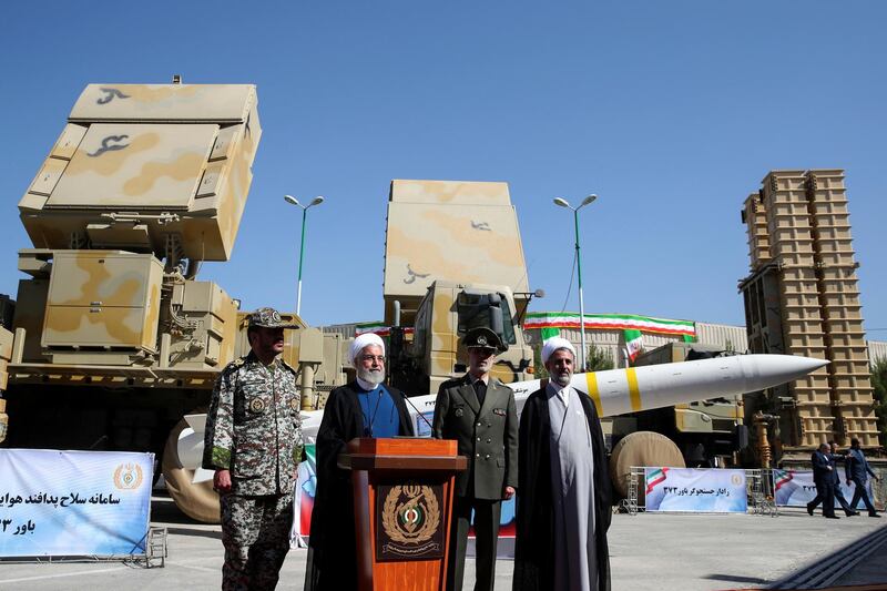 In this photo released by the official website of the office of the Iranian Presidency, President Hassan Rouhani, second left, speaks during a ceremony to unveil the Iran-made Bavar-373, a long-range surface-to-air missile system, displayed at rear, as his Defense Minister Gen. Amir Hatami, second right, commander of army's air defense force Gen. Alireza Sabahifard, left, and the chairman of the parliament's National Security and Foreign Policy Committee Mojtaba Zolnour, listen, at an undisclosed location in Iran, Thursday, Aug. 22, 2019. Rouhani struck a muscular tone on dealings with the U.S., saying Thursday that "talks are useless" as Tehran's nuclear deal with world powers crumbles further. (Iranian Presidency Office via AP)