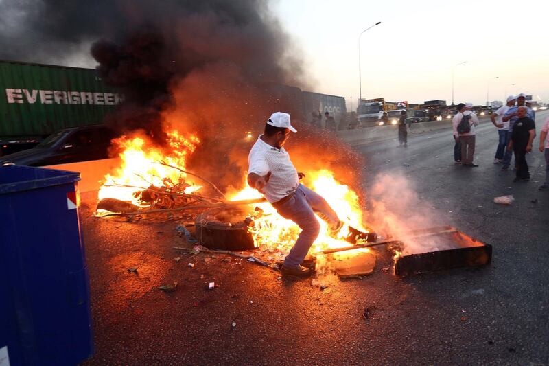 Retired army officers and soldiers burn tyres as they block a road during a protest over a state budget that includes a provision taxing their pensions, in Naameh, south of Beirut, Lebanon. EPA