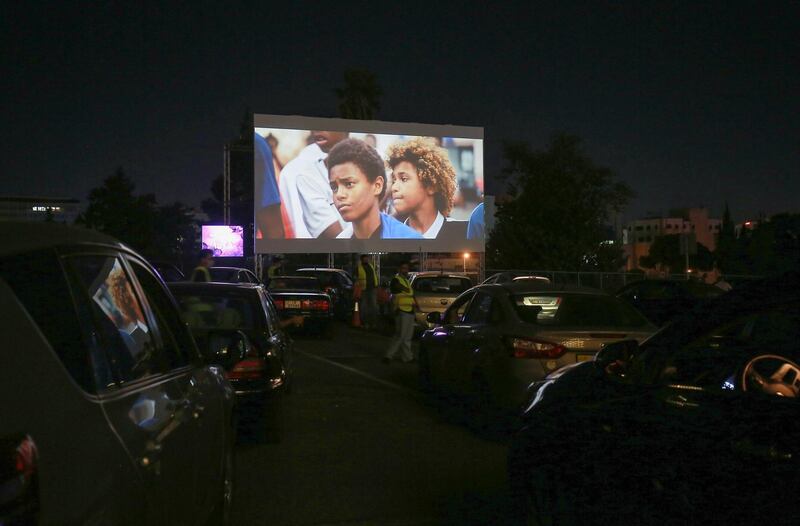 Jordanians sit in their cars at their country's first drive-in cinema, which opened with the French film 'Les Miserables' by Ladj Ly, at a car park in New Abdali district in the capital Amman.   AFP