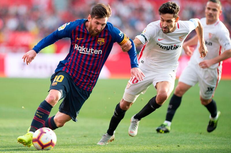 Messi looks to make a break as he challenged by Sevilla. AP